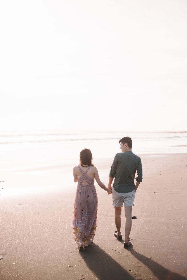 A couple walking on the beach, indicative of the peace that couples therapy can provide to a relationship